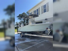 A pristine center console boat parked on a trailer, showcasing its sleek design and ready for adventure. Perfect for fishing or family outings on the water.