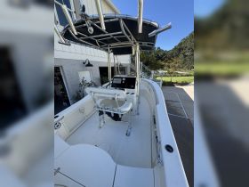 An interior view of a well-equipped boat helm featuring seating and a console, perfect for fishing or cruising adventures.