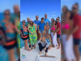 A joyful group poses together on a boat, capturing a memorable moment during their aquatic adventure — perfect for family gatherings or celebrations on the water.