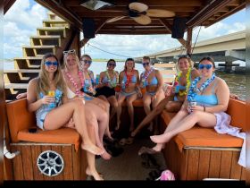 A lively group of friends enjoys drinks and celebration aboard a boat, perfect for summer parties and memorable outings on the water.