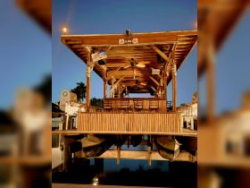 A beautifully designed interior of a boat featuring bamboo seating and a cozy dining area, perfect for gatherings and enjoying the waterfront ambiance.