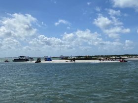 A vibrant scene at a sandbar with groups enjoying jet skiing and beach activities, showcasing the perfect summer getaway on the water.