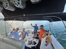 A cheerful group enjoys drinks aboard a boat, celebrating together on the water — perfect for memorable outings and gatherings.