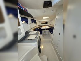 Interior view of a cozy boat cabin featuring seating and a small kitchenette, perfect for relaxing during a day on the water.
