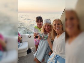 A joyful group of friends raises their glasses in a toast while enjoying a sunset cruise, capturing the essence of celebration on the water.