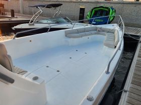 The interior of a sleek boat featuring comfortable seating and a spacious layout, perfect for relaxing on the water.