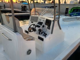 A clean and modern helm area of a boat, featuring comfortable seating and essential navigation equipment, perfect for a day on the water.