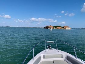 A scenic view from the front of a boat, showcasing the tranquil waters and an abandoned structure in the distance — perfect for exploring coastal landscapes.