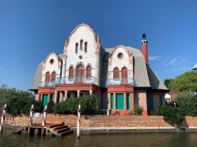 A picturesque view of a unique architectural structure along the water, showcasing intricate design elements and vibrant colors.