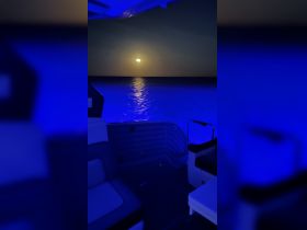 A serene view from inside a boat, showcasing comfortable seating with a stunning sunset reflected on the water — perfect for evening cruises.