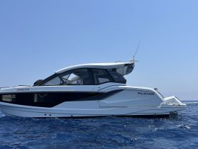 A sleek yacht named 'Angelica' glides through the clear blue waters, showcasing its modern design and elegance.