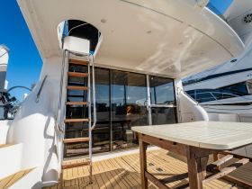 Interior view of a yacht showcasing a stylish cabin area with a ladder leading to the upper deck, perfect for relaxing and enjoying the marine environment.