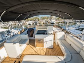 An inviting interior view of a boat's cabin featuring comfortable seating and a well-equipped helm, perfect for relaxing or entertaining while on the water.