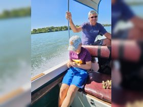 A joyful moment on a boat with a child and an adult enjoying a scenic ride on the water, perfect for family adventures and bonding experiences.