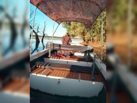 A person captures the serene landscape from the interior of a boat, showcasing comfortable seating and a peaceful environment for nature photography.