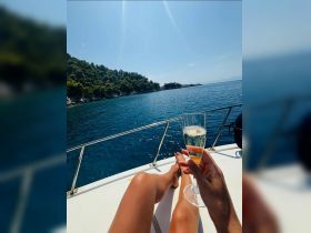 A relaxing moment on a yacht with a glass of champagne, showcasing stunning coastal scenery — perfect for celebrating special occasions on the water.