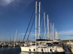 A stunning view of a yacht docked in a marina, surrounded by other vessels under a clear blue sky — perfect for showcasing boating adventures.