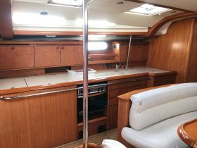 Interior view of a well-equipped boat cabin featuring a spacious kitchen area and comfortable seating, perfect for relaxing during trips on the water.