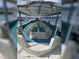 Interior view of a spacious boat cabin featuring comfortable seating and a helm, perfect for relaxing while cruising on the water.