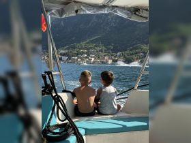 Two children enjoy the scenic view from the back of a boat, creating a perfect moment of adventure on the water.
