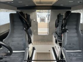 Interior view of a modern boat cabin showcasing comfortable seating and helm area, perfect for a smooth sailing experience.