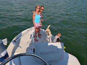 A joyful family enjoys a day on the water with their dog, capturing the essence of fun and togetherness while boating.