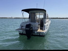 A clear view of a sleek boat from the back, showcasing its design and motor while cruising through calm waters — perfect for a day out on the sea.