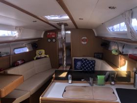 Interior view of a cozy boat cabin featuring comfortable seating and playful decor, perfect for relaxing during a sailing adventure.