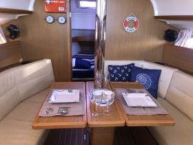 A cozy interior view of a boat's dining area, featuring elegant table settings and comfortable seating, perfect for enjoying meals while on the water.