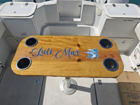 A beautifully crafted wooden table with drink holders, featuring the name 'Luli Mar' — perfect for enjoying refreshments while on the water.