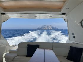 A stunning view from inside a boat, showcasing the wake and a distant island, perfect for capturing the essence of a scenic ocean journey.