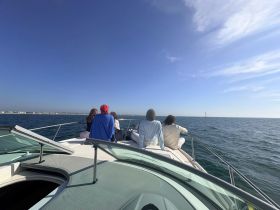 A group of friends enjoys a scenic boat ride on the ocean, taking in the beautiful views and the thrill of sailing.