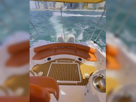 Interior view of a boat's seating area, featuring comfortable cushions and a stylish helm, perfect for enjoying a day on the water.
