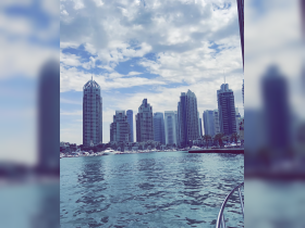 A stunning view of Dubai's skyline from the water, showcasing modern architecture and vibrant waterfront life — perfect for sightseeing and exploring the city by boat.