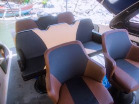 Interior view of comfortable seating arrangements on a boat, perfect for relaxing during a day on the water.