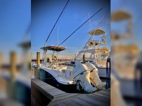 A sleek boat docked at the marina, showcasing its impressive structure and design against a vibrant sky — perfect for fishing or leisure outings.