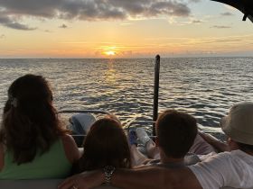 A family enjoys a picturesque sunset aboard a pontoon boat, creating lasting memories on the water.