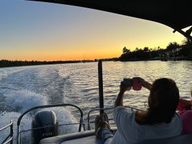 A couple enjoys sunset drinks on a pontoon boat, capturing the perfect moment of relaxation and celebration on the water.
