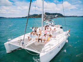 A lively group enjoys a fun day aboard a catamaran, celebrating together against a stunning ocean backdrop — perfect for unforgettable gatherings on the water.