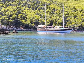 A stunning yacht anchored in tranquil waters, surrounded by lush greenery — perfect for exploring serene coastal destinations.