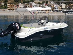 A sleek motorboat named 'Try It Love It' docked in clear waters, showcasing its modern design against a picturesque coastal backdrop.