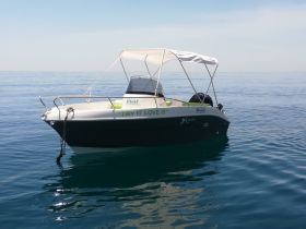 A sleek boat named 'Try It Love It' floats serenely on calm waters, showcasing its stylish design and perfect for water adventures in Sicily.