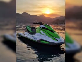 A vibrant green and white jet ski sits on calm waters at sunset, showcasing the perfect water sports experience in Sicily.