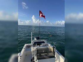A scenic view from a Pathfinder boat with a diver in the water, showcasing the excitement of snorkeling adventures in clear blue waters.