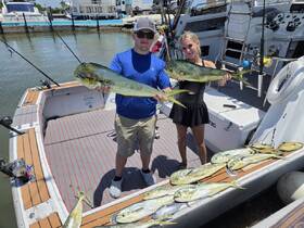 A successful fishing trip captured with two anglers proudly displaying their catch on the deck of a boat, showcasing the thrill of deep-sea fishing.