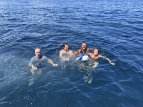 A joyful group enjoys a refreshing swim in the ocean, creating lasting memories during their boating adventure.