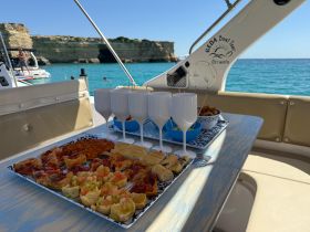 A beautifully arranged spread of snacks and cocktails on a boat, perfect for enjoying a relaxing day on the water with friends or family.