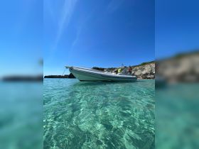 A sleek speedboat anchored in crystal-clear waters, showcasing the perfect setting for a day of adventure on the water.