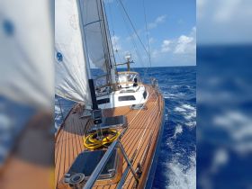 A beautiful sailboat glides through the open ocean, showcasing its elegant design and the vibrant blue waters, perfect for sailing enthusiasts.