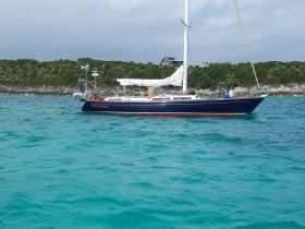 A beautiful sailboat named 'Sacred Space' anchored in clear turquoise waters, showcasing the perfect setting for a relaxing day on the water.